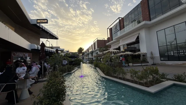 مجمع تجاري سعودي خارجي مع نافورة وقت الغروب