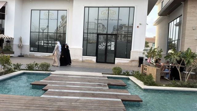 أشخاص يتجولون في ساحة تسوق خارجية حديثة