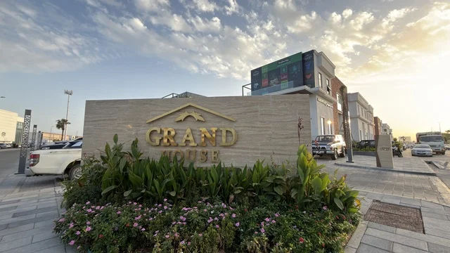 لوحة مدخل جراند هاوس والواجهة الخارجية للشارع