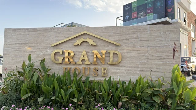 Grand House Sign on Stone Wall with Plants