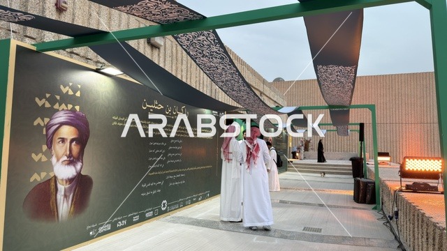 معرض راكان بن حثلين مع رجال سعوديين بالزي الرسمي