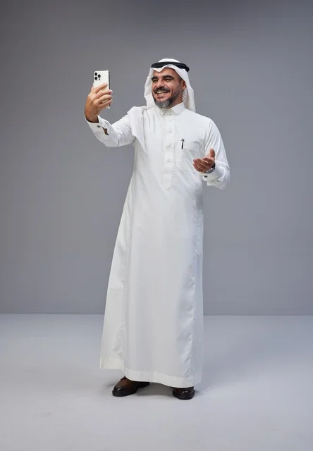 رجل سعودي بالزي التقليدي يلتقط سيلفي بالهاتف