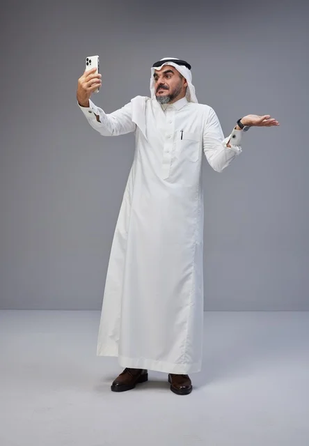 Saudi Man in Traditional Thobe Taking Studio Selfie