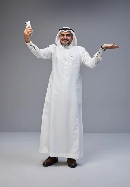 Saudi Man in Traditional Thobe Taking Mobile Selfie