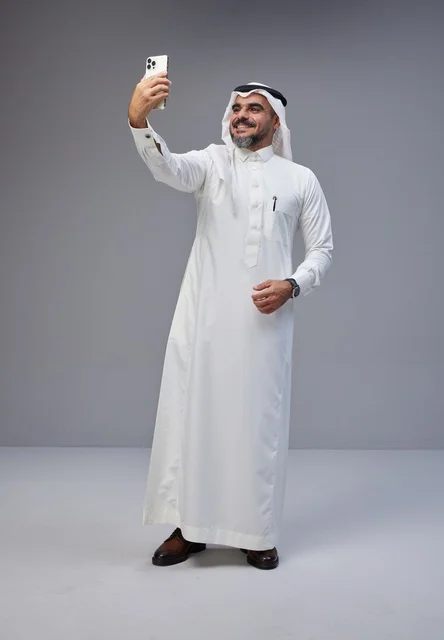 رجل سعودي يلتقط سيلفي بالهاتف في استوديو