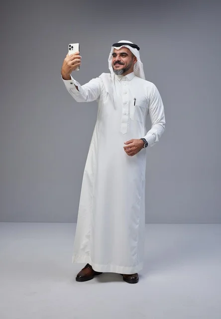 Saudi Man in Traditional Thobe Taking Smartphone Selfie