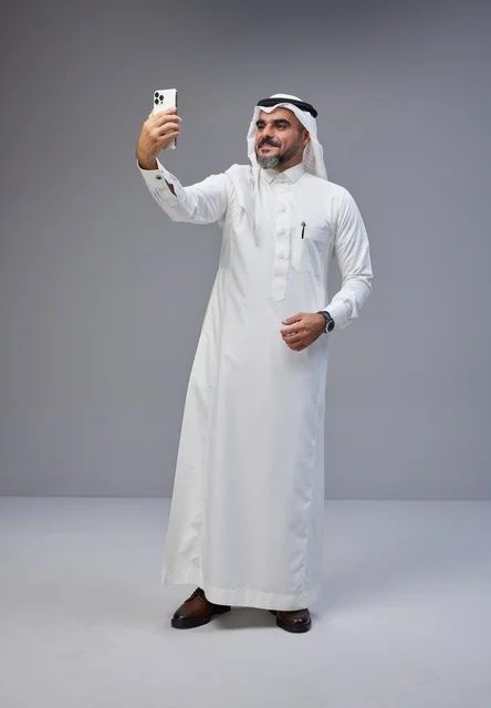 رجل سعودي بالزي التقليدي يلتقط سيلفي بالهاتف