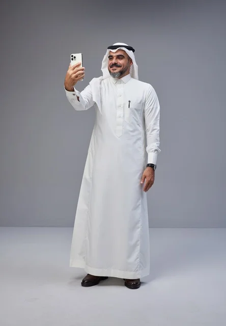 Saudi Man in Traditional Thobe Taking Smartphone Selfie