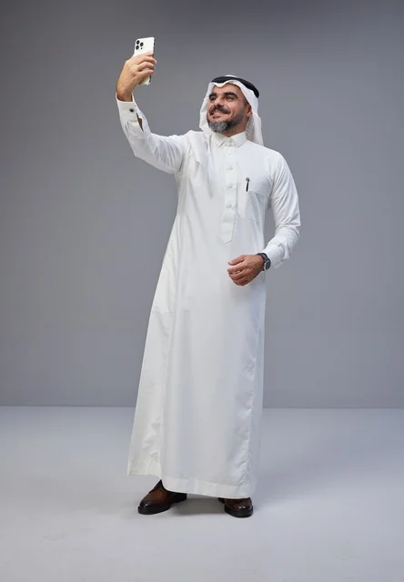 رجل سعودي بالزي التقليدي يلتقط صورة سيلفي