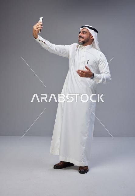Saudi Man in Traditional Thobe Taking Mobile Selfie