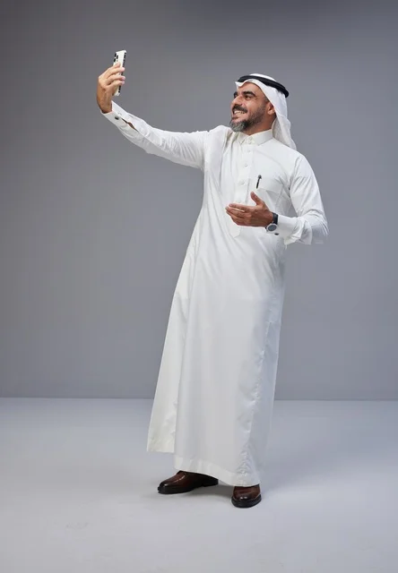 Saudi Man in Traditional Thobe Taking Mobile Selfie