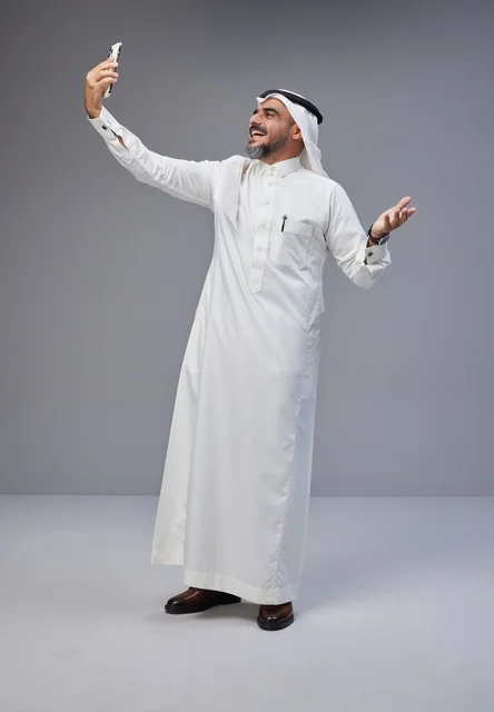 Saudi Man in Traditional Thobe Taking Smartphone Selfie