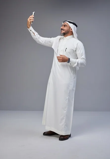 رجل سعودي بالزي التقليدي يلتقط سيلفي بالهاتف