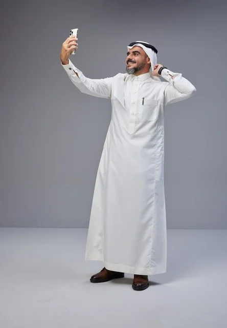 Saudi Man in Traditional Thobe Taking Smartphone Selfie