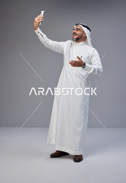 رجل سعودي بالزي التقليدي يلتقط صورة سيلفي