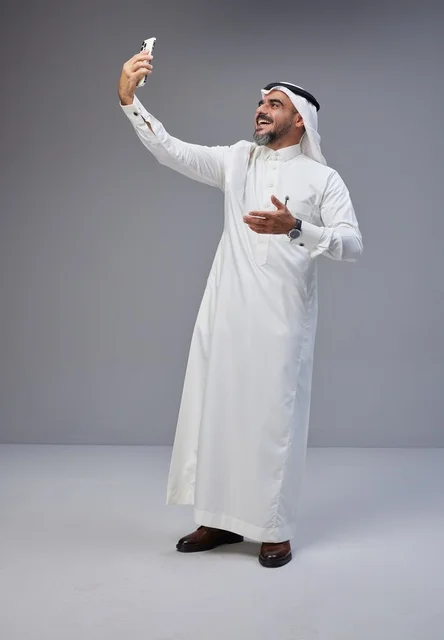 رجل سعودي بالزي التقليدي يلتقط صورة سيلفي