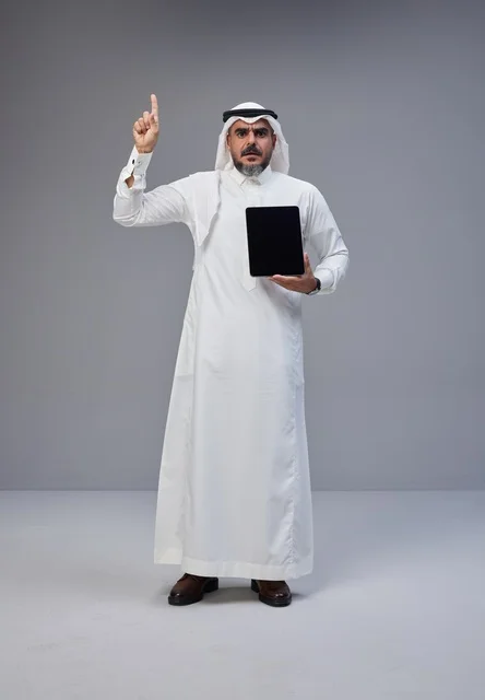 Saudi Man Holding Tablet Pointing Upward Studio