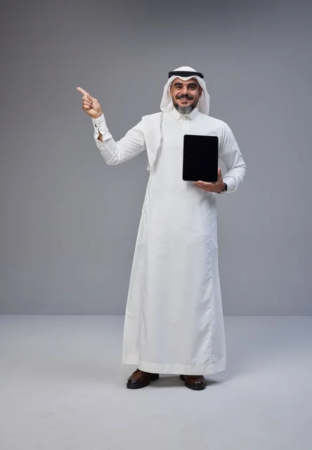Saudi Man Holding Blank Tablet Pointing Upwards in Studio