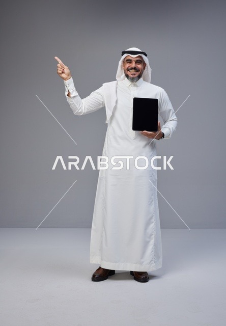 Saudi Man Holding Blank Tablet and Pointing Up