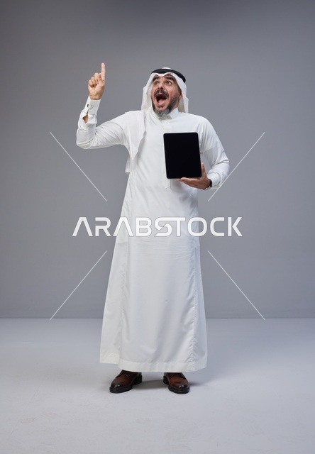 Saudi Man with Tablet Pointing Up Excited Studio Shot
