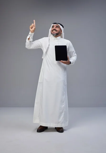 Saudi Man Holding Tablet and Pointing Up in Studio