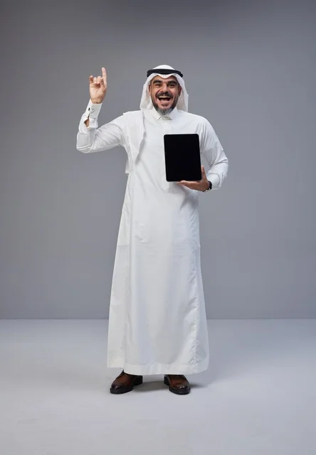 Saudi Man Holding Tablet Pointing Up in Studio