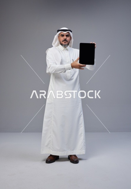 Saudi Man in Traditional Thobe Holding Blank Tablet