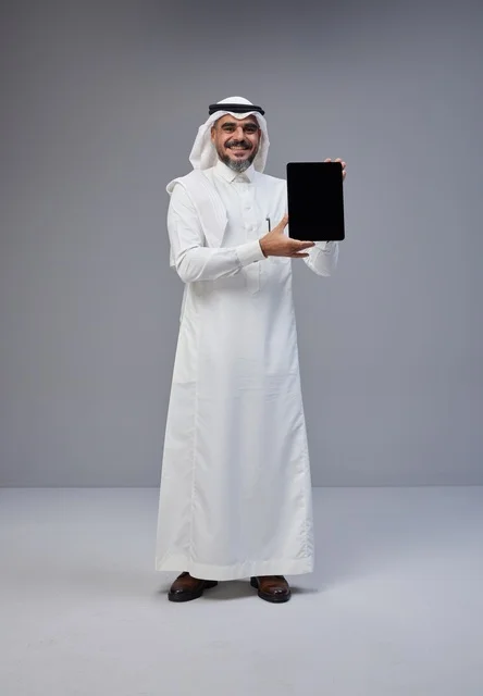رجل سعودي يحمل جهاز لوحي بشاشة فارغة