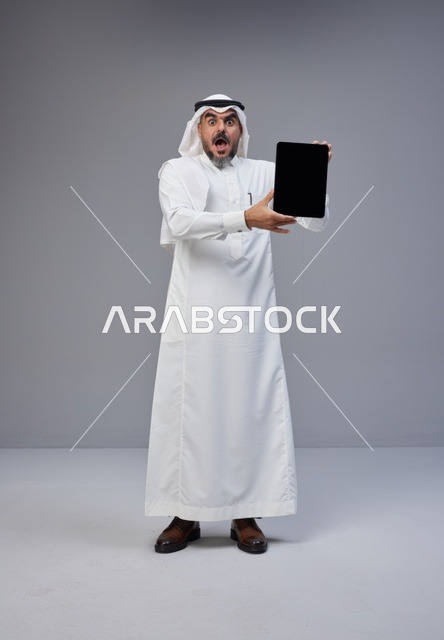 Surprised Saudi Man Holding Tablet Blank Screen