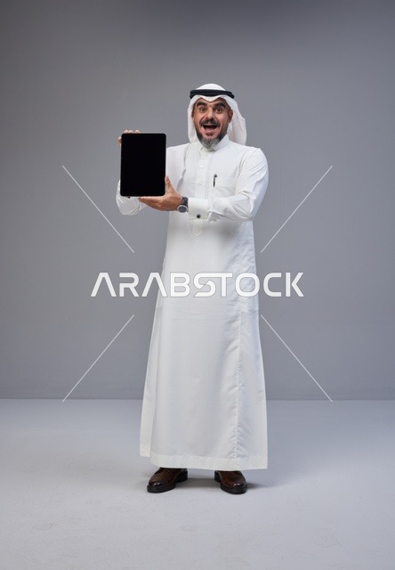 Saudi Man in Thobe Holding Tablet with Blank Screen