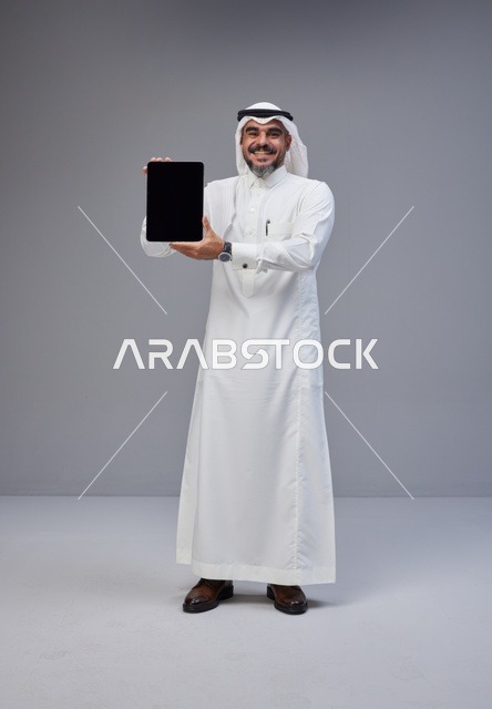 Saudi Man in Traditional Thobe Holding Blank Tablet