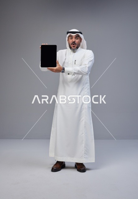 Saudi Man Holding Blank Tablet with Surprised Face
