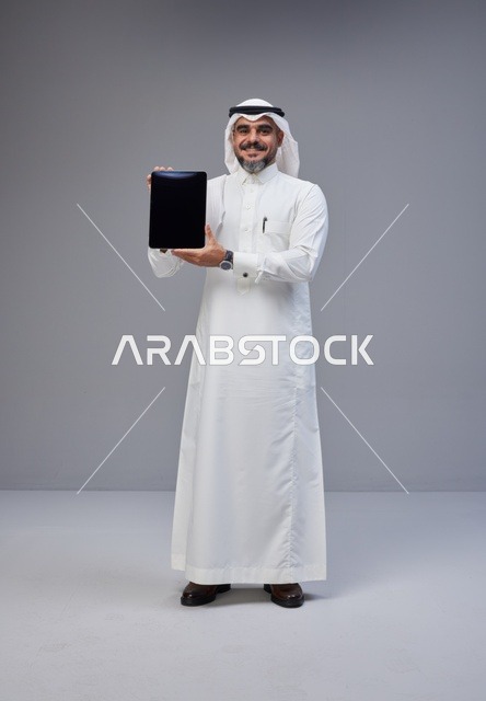 Saudi Man in Traditional Thobe Holding Tablet Mockup