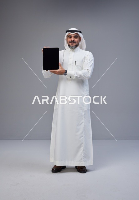 Saudi Man Holding Tablet with Blank Screen in Studio