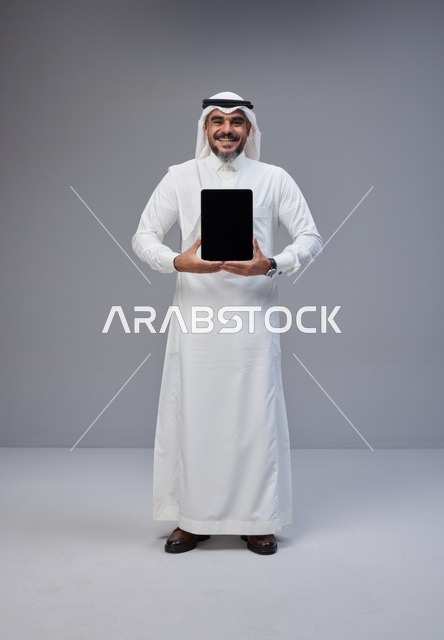 Saudi Man in Traditional Thobe Holding Blank Tablet