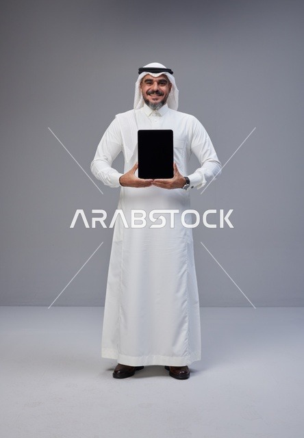Saudi Man in Traditional Thobe Holding Blank Tablet
