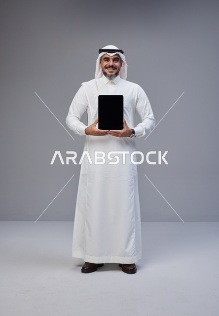 Saudi Man Holding Tablet with Blank Screen in Studio