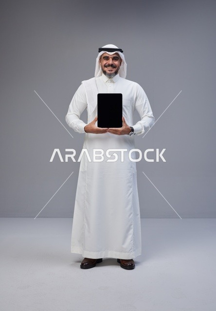 Saudi Man in Traditional Thobe Holding Blank Tablet