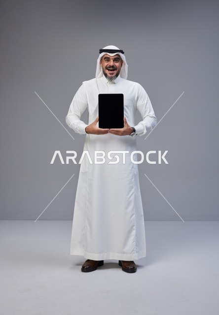 Saudi Man in Traditional Thobe Holding Blank Tablet