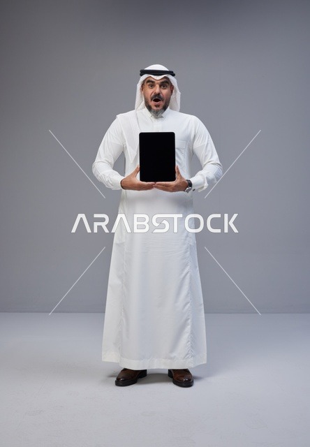 Surprised Saudi Man Holding Tablet with Blank Screen