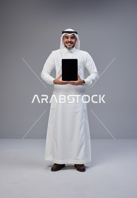Saudi Man in Thobe Holding Tablet with Blank Screen