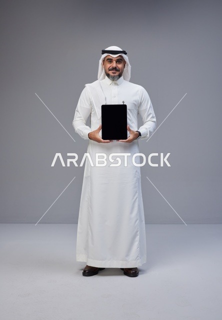 Saudi Man in Traditional Thobe Holding Blank Tablet
