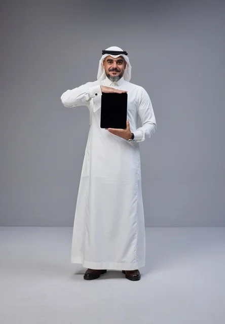 Saudi Man in Traditional Dress Holding Tablet in Studio