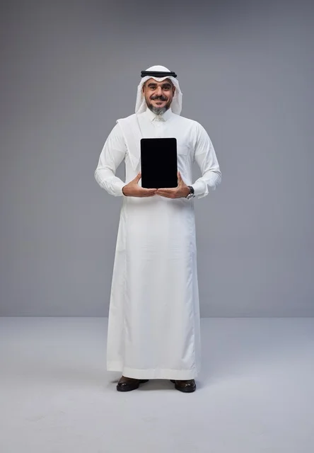 Saudi Man in Traditional Dress Holding Blank Tablet