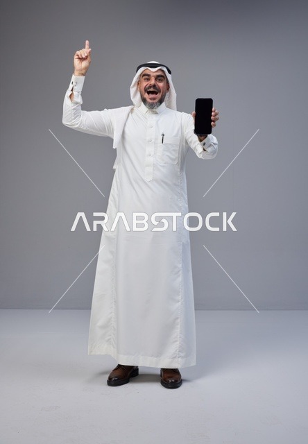 Saudi Man Holding Blank Smartphone Screen in Studio