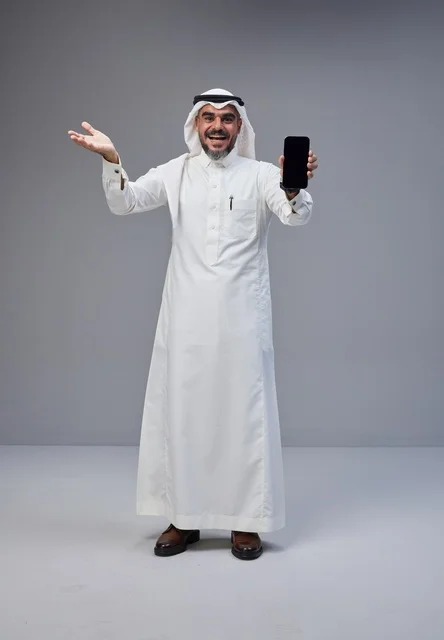 رجل سعودي يحمل هاتفاً ذكياً بشاشة فارغة