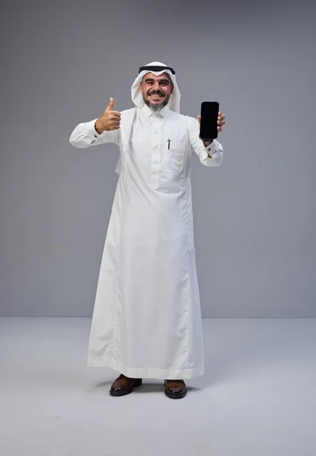 Saudi Man in Traditional Dress Holding Smartphone Thumbs Up