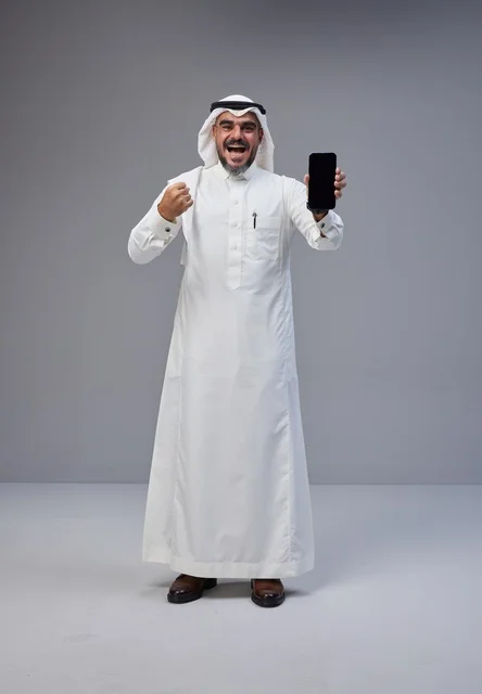 Saudi Man Holding Blank Smartphone in Victory Pose