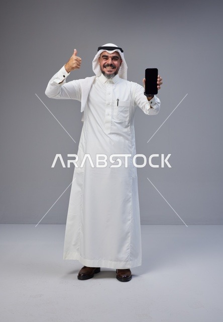 Saudi Man with Smartphone Blank Screen and Thumbs Up