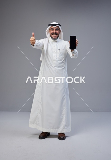 Saudi Man Holding Blank Smartphone Screen with Thumbs Up